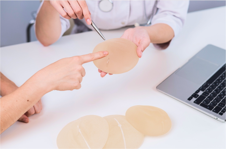 Breast augmentation surgeon holding a breast implant